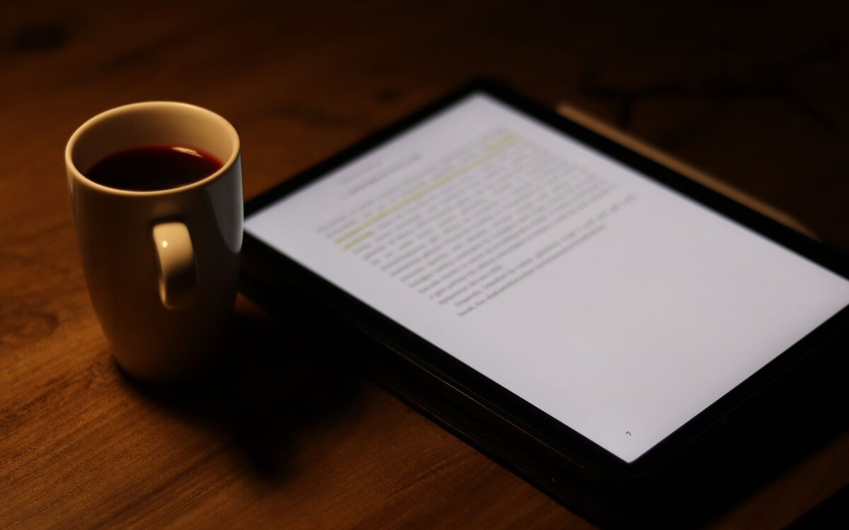 Leitura no tablet com uma xícara de café